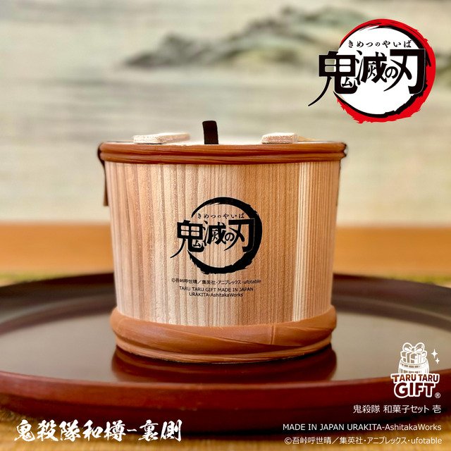 Barril de madera del set de dulces de Kimetsu no Yaiba, con el logo de la serie estampado, presentado sobre una bandeja lacada